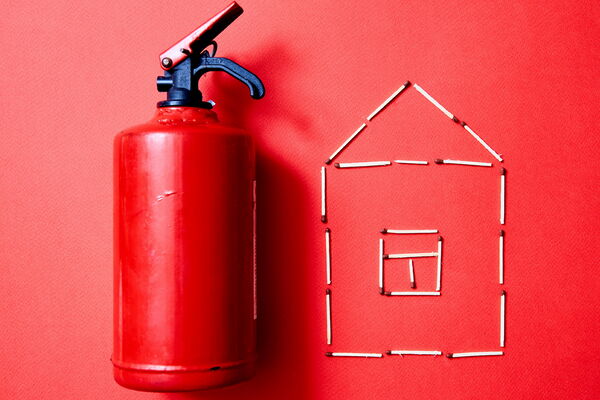Bild mit Feuerlöscher und Haus aus Streichhölzern