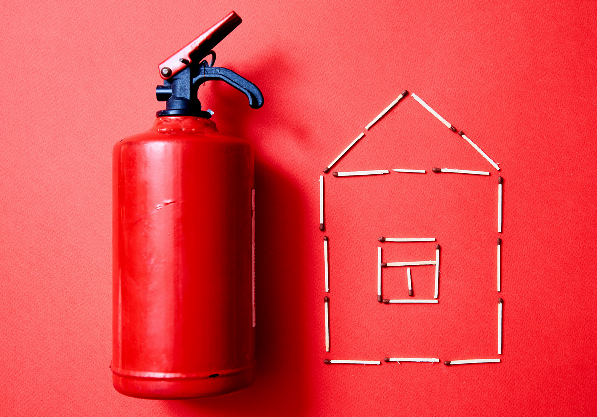 Bild mit Feuerlöscher und Haus aus Streichhölzern