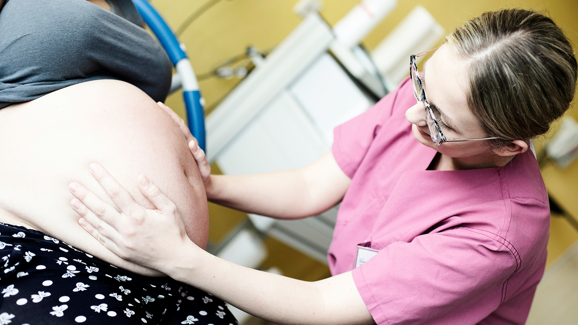 Bild Hebamme untersucht schwangere Frau