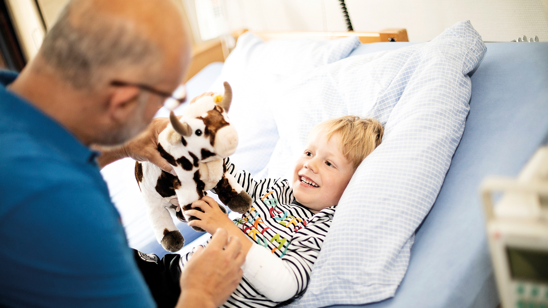 Arzt spielt zusammen mit einem Kind und Kuscheltier