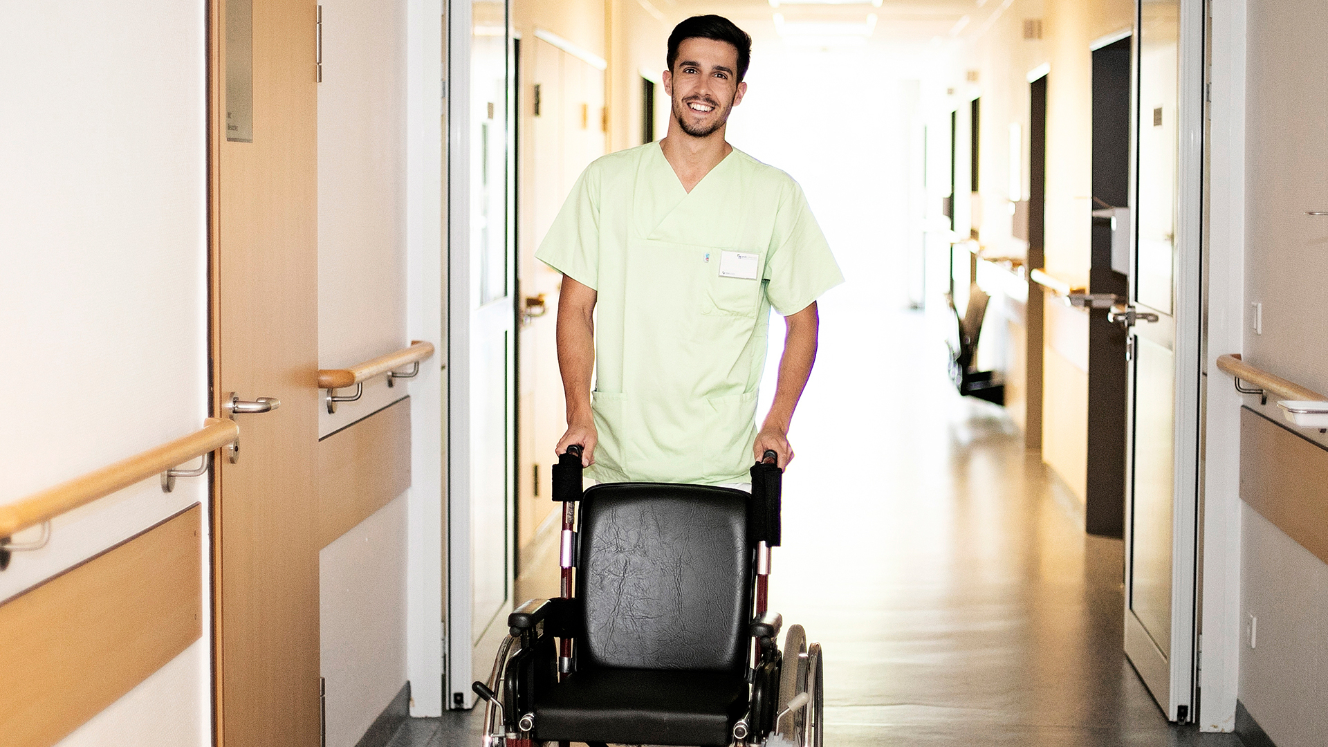 Bild Pfleger schiebt Rollstuhl